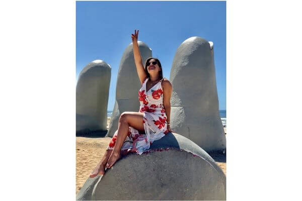 Millena na escultura La Mano na Playa Brava em Punta del Este, Uruguai