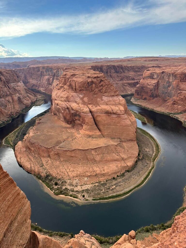 Vista panorâmica do Horseshoe Bend com o Rio Colorado formando uma curva em ferradura e pôr do sol ao fundo