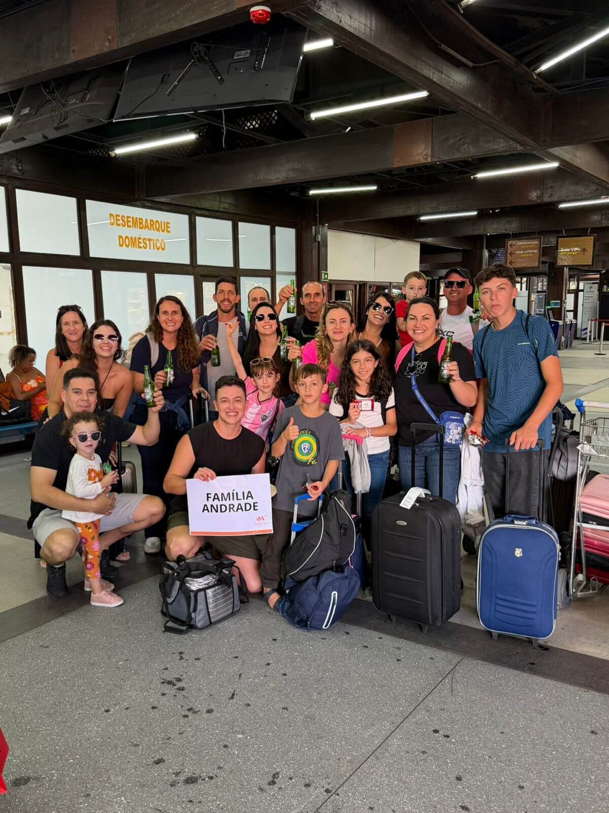 Família sendo recepcionada de surpresa no aeroporto de Porto Seguro com cerveja, amendoim e chocolate para as crianças