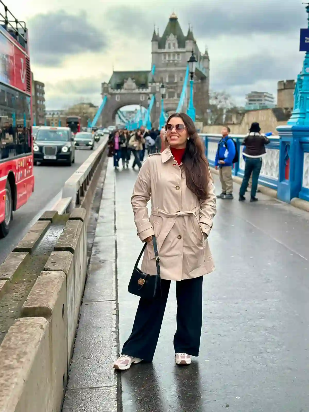 Mulher sorrindo na Tower Bridge durante escala em Londres