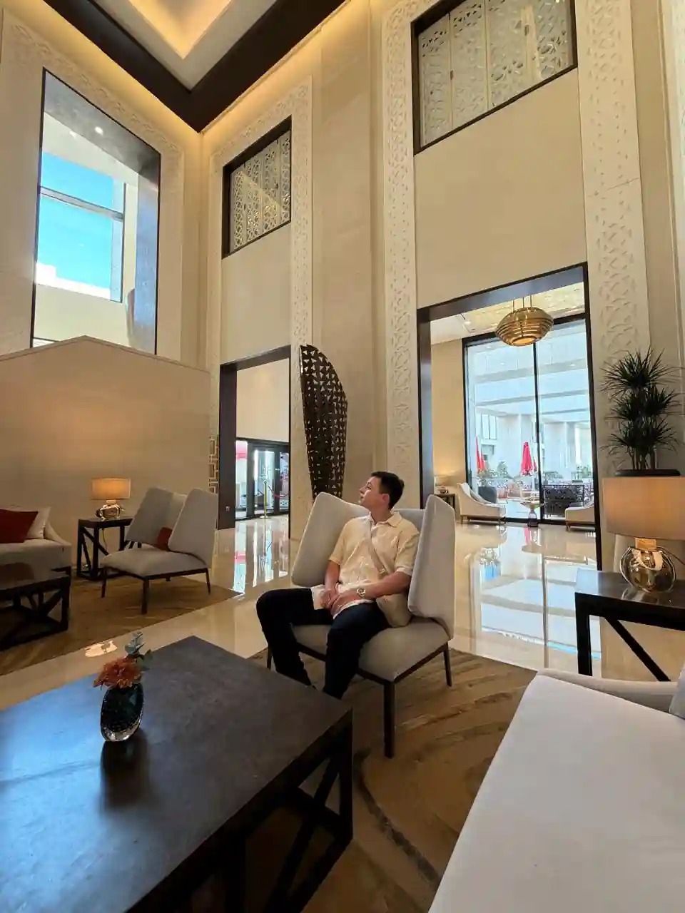 Homem sentado no lobby do Alwadi Hotel Doha MGallery Collection