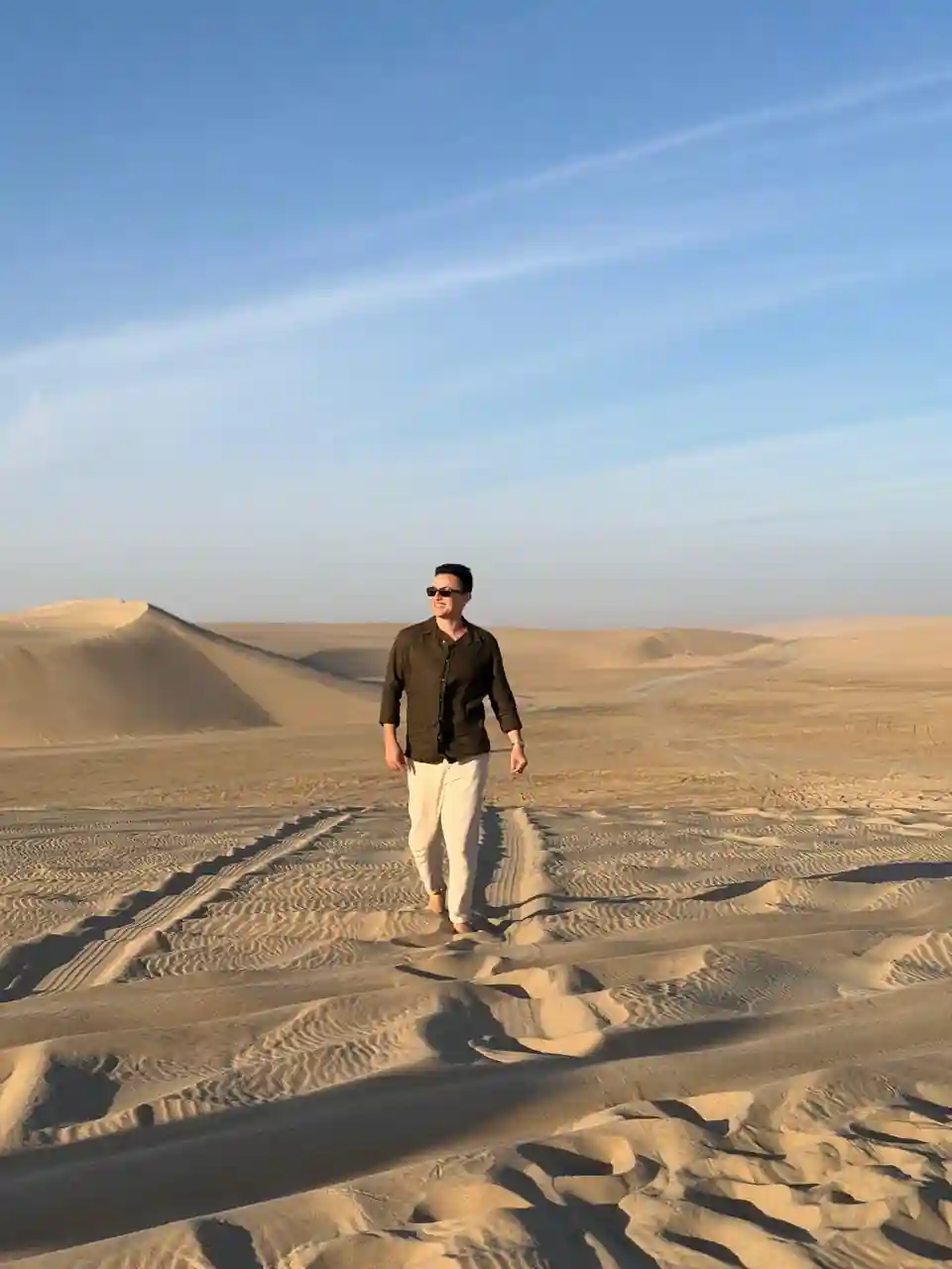 Homem caminhando pelas dunas do deserto durante Desert Safari em Doha