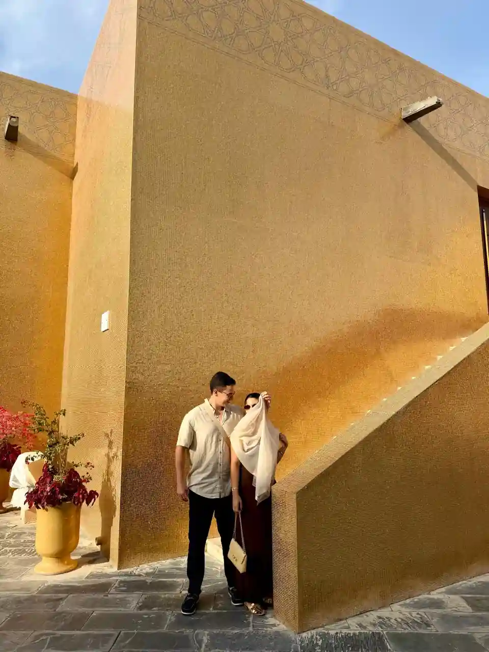 Casal na escada da mesquita dourada no Katara Cultural Village em Doha