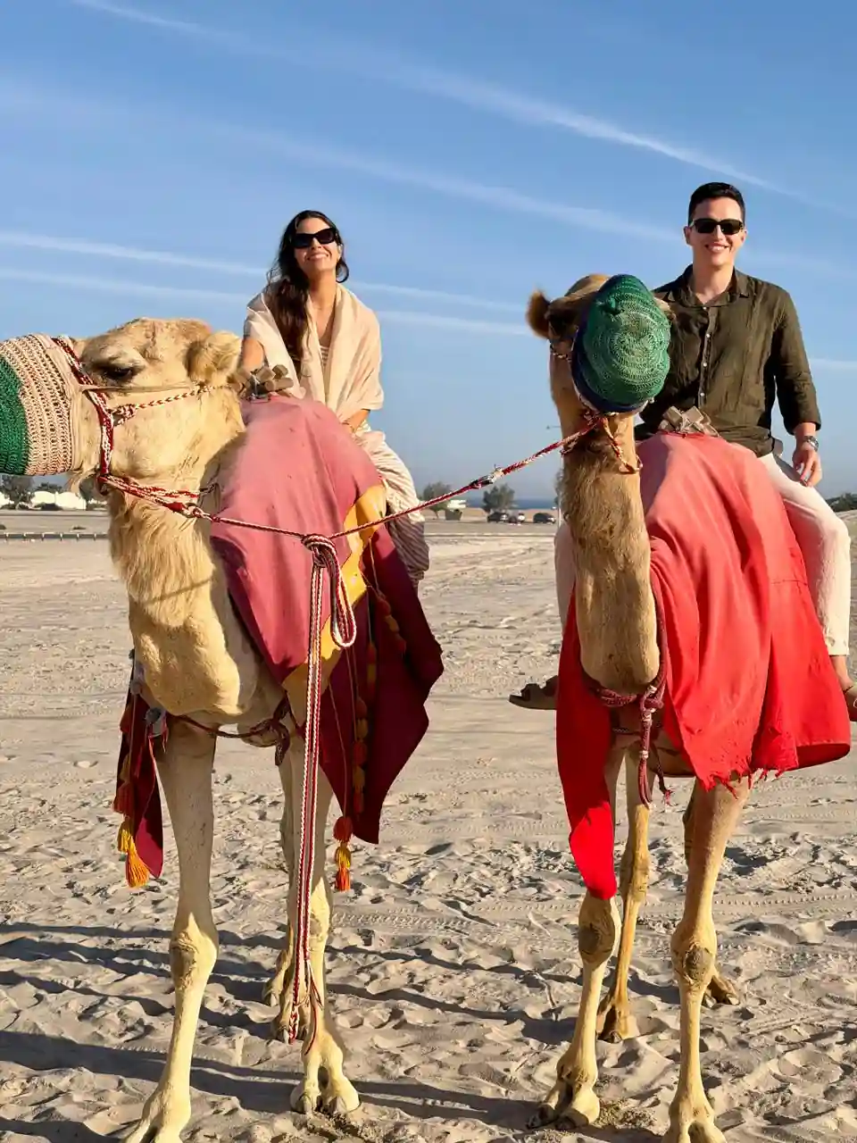Casal andando de camelo durante passeio no deserto em Doha, Catar