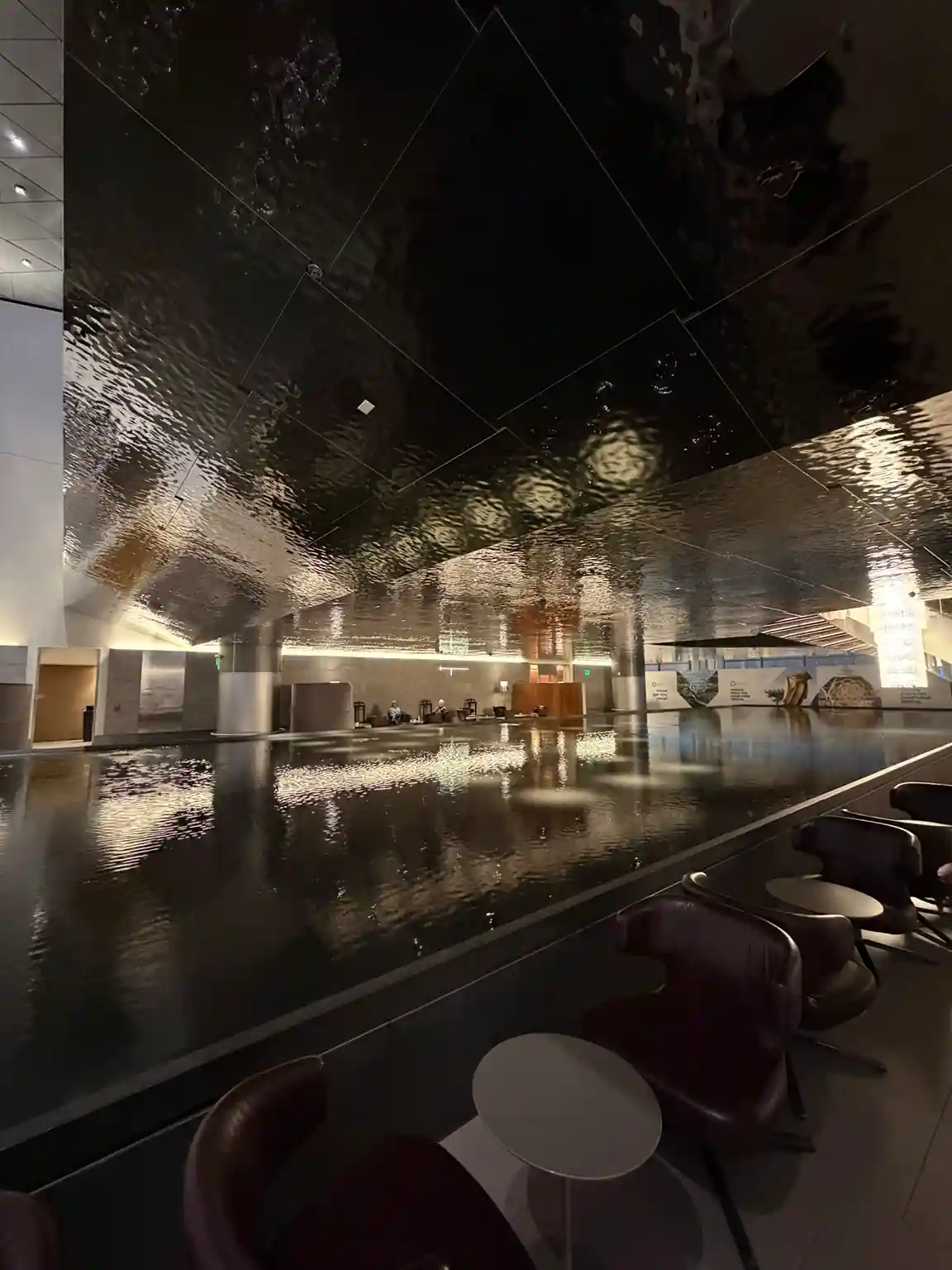 Lago artificial com reflexo no teto da Al Mourjan Business Lounge South no Aeroporto Hamad de Doha