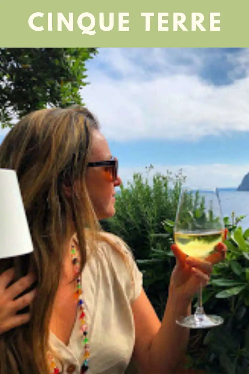 Vista do mar em Cinque Terre, na Itália, com taça de vinho branco em primeiro plano