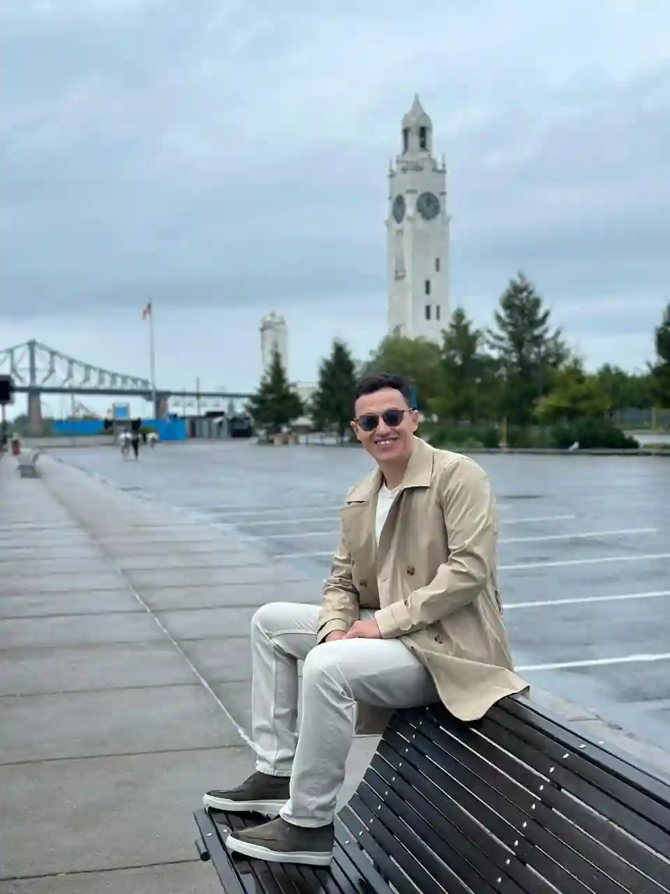 Matheus sentado no Vieux-Port de Montreal com a torre do relógio ao fundo